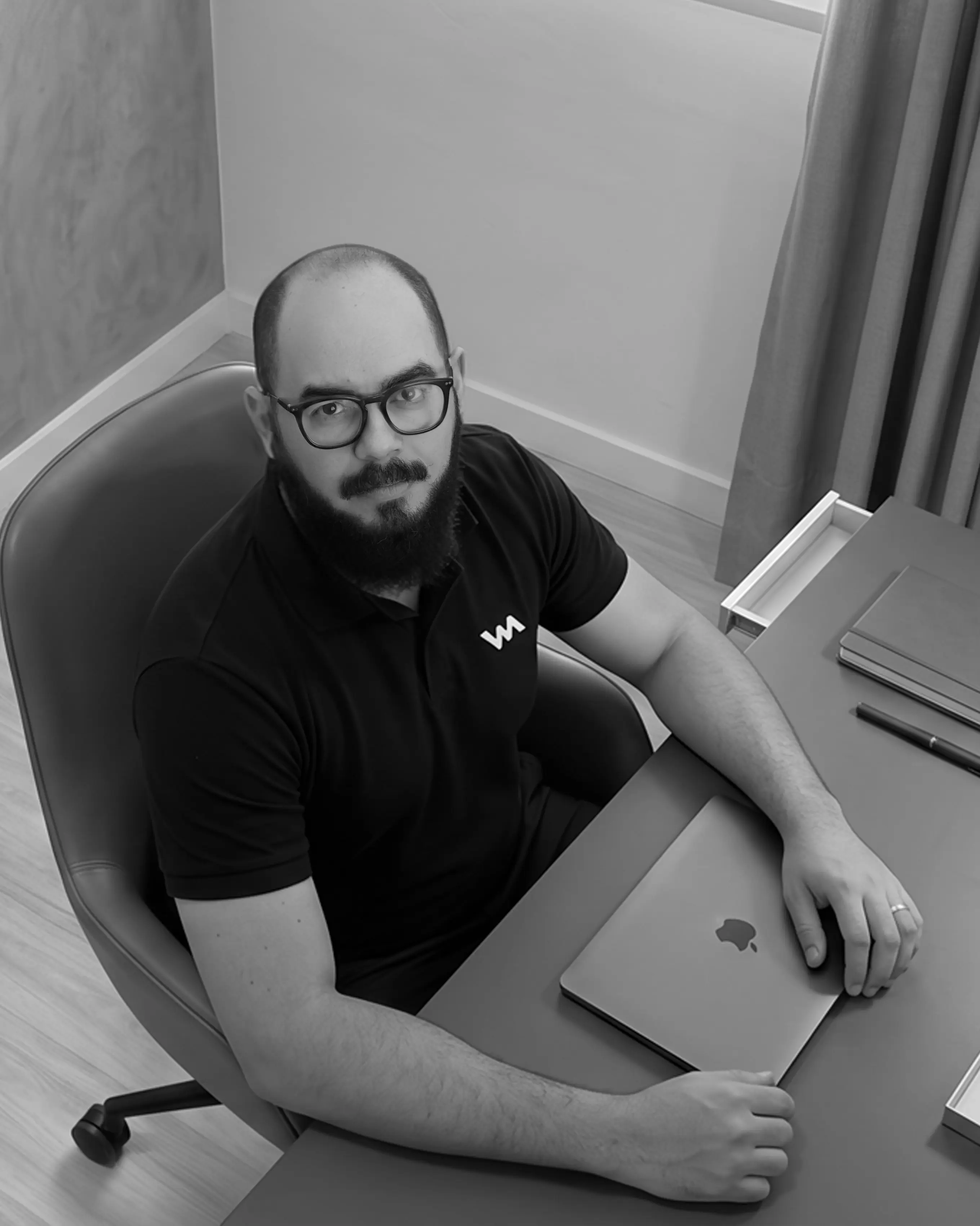 Vitor Mourão, designer gráfico, sentado à mesa de trabalho em Belo Horizonte